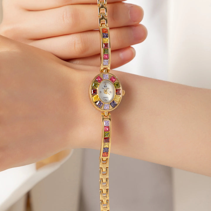 Amelie – Goldene Uhr mit kristallinem Rahmen.