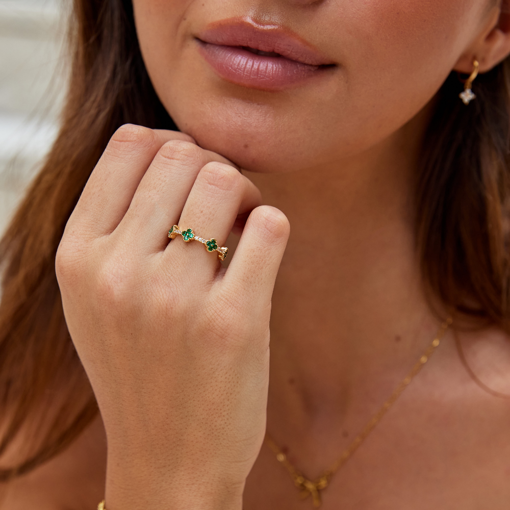 Annika – Vergoldeter Ring mit floralen Details und einem smaragdgrünen Element.