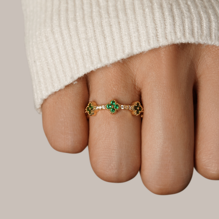 Annika – Vergoldeter Ring mit floralen Details und einem smaragdgrünen Element.
