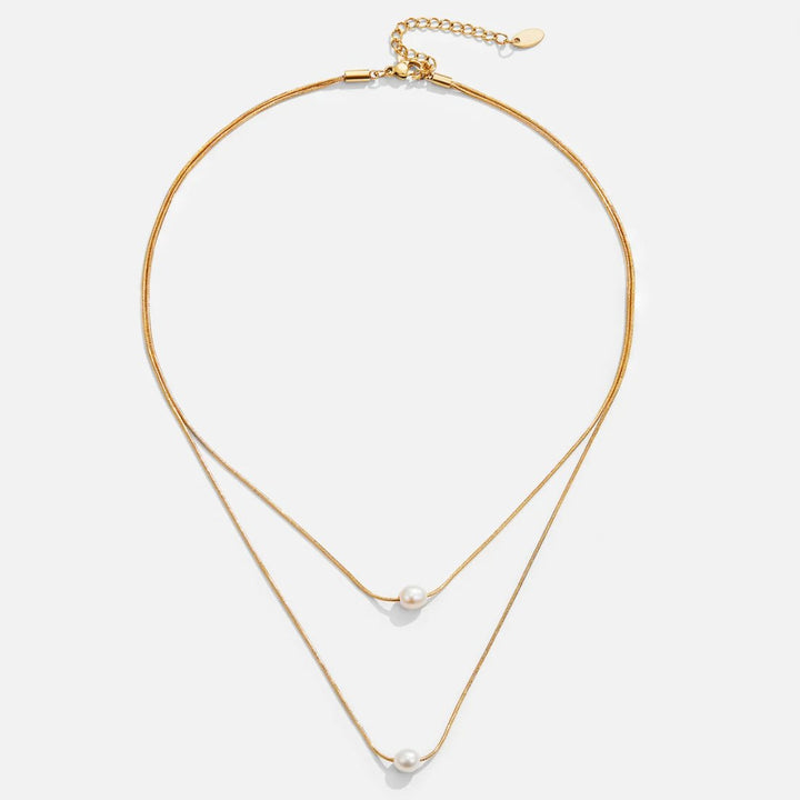 Sabine – Zweilagige goldene Kette mit dunklem Stein.